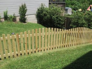 Wood Spaced Board Fence in Backyard Lawn